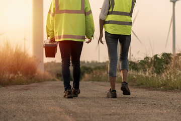 Close-up leg couple walking in the wind turbine farm.