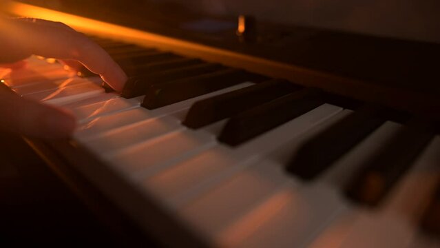 Musician or composer plays piano or midi keyboard in recording studio.Creative dramatic light.Concept of music