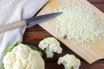 raw homemade cauliflower rice over rustic wooden table