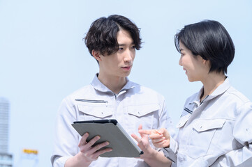 Men and women in work clothes consulting on site.