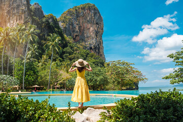 Woman tourist in yellow dress and hat traveling on Railay beach, Krabi, Thailand. vacation, travel,...
