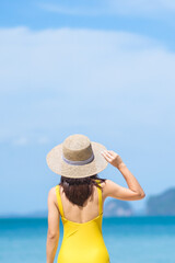 Fototapeta na wymiar Woman tourist in yellow swimsuit and hat, happy traveler sunbathing at Paradise beach on Islands. destination, wanderlust, Asia Travel, tropical summer, vacation and holiday concept