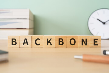 バックボーンのイメージ｜「BACKBONE」と書かれた積み木とデスク