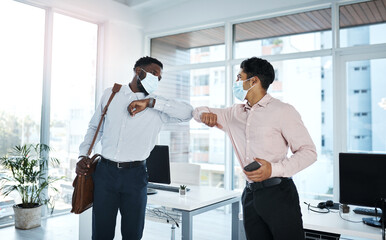 Naklejka na ściany i meble A new greeting adopted during the pandemic. Shot of two businessmen bumping elbows in an office.
