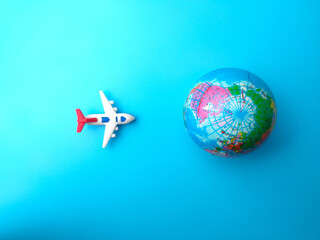 Top view airplane with earth globe on a blue sky background. Travel concept.