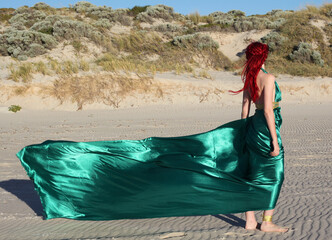 Full length portrait of  red haired woman wearing a  beautiful  long green  silk toga gown....