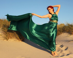 Full length portrait of  red haired woman wearing a  beautiful  long green  silk toga gown....