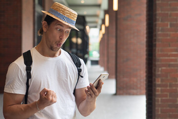 happy excited man traveler using smartphone, discovering grand sale offer, good online deal, fast...