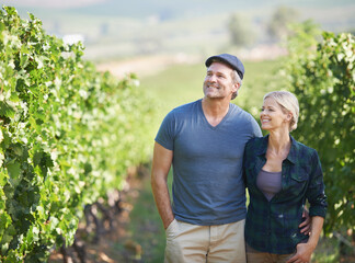 I cant believe how fast theyve grown. A happy mature couple spending time in their vineyard.