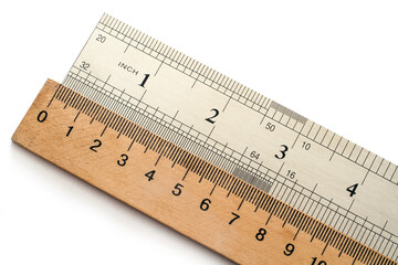 Metal and wooden rulers on a white background. Metric and American system of measurement.