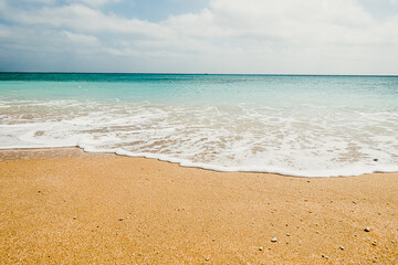 Low angle shot of beach waves with sky