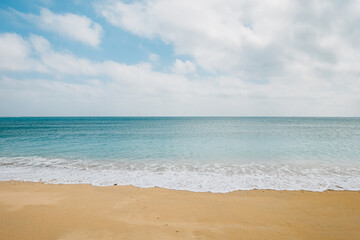 Fototapeta na wymiar Deserted beach waves and sky