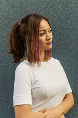 A thoughtful portrait of a cute young woman with pink purple violet hair wearing a white t-shirt...