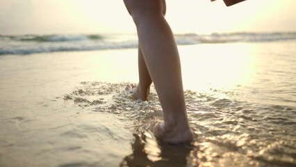 Young woman walk into the sea with sunset moment. Happy female relaxing on vacation time holiday weekend after hard work all day. Travel and resting on the beach concept.