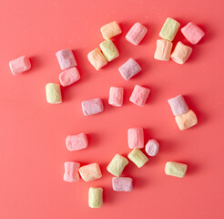 Multicolored candies on a pink background. Close-up