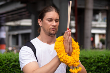 Westerner man attending Indian religion prayer's worship, concept image of religion freedom of...