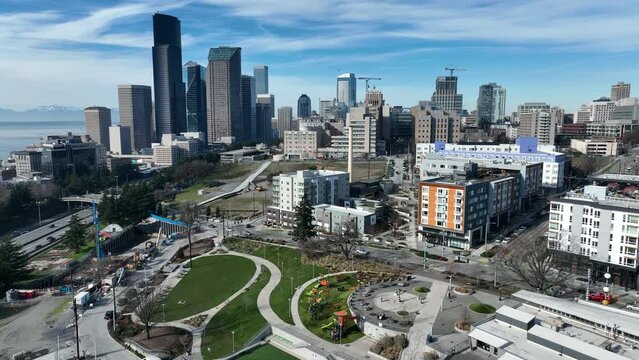 Cinematic 4K aerial drone orbit shot of First Hill, Yesler Terrace Park and Spraypark, Cherry Hill, Squire Park, skyscrapers and high-rise commercial buildings downtown Seattle, Washington