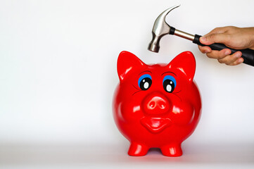 Red piggy bank with hand holding the hammer puts on white background with space for text.