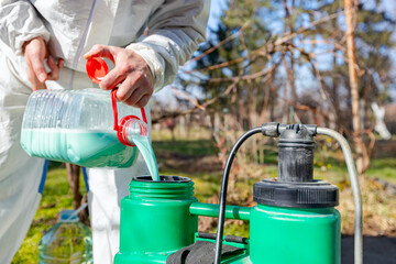 Gardener is blending substance with water in proper scale for sprinkles fruit trees