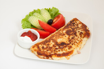 Classic omelet with cheese and tomatoes and cucumbers salad on a white plate