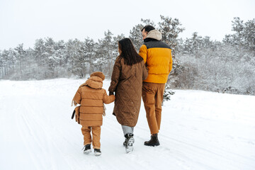 Happy family having a walk in winter outdoors in snow