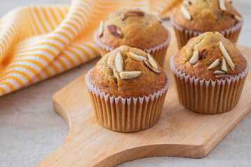 Banana muffins with almond on wooden board