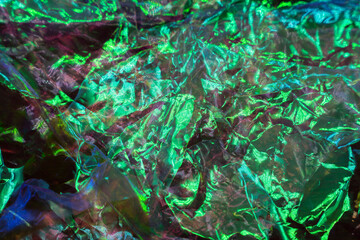 colorful grunge background. Rough texture. Neon light red green blue shiny wrinkled rock dark abstract art.