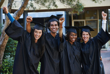 Nothing can stop us now. A group of smiling college graduates celebrating their graduation.