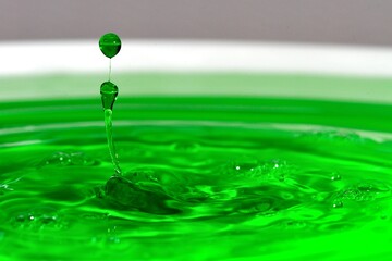 Grüne Tropfen springen aus dem Wasser.