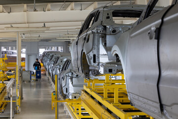 Photo of automobile production line. Modern car assembly plant. Modern and high-tech automotive industry. Conveyor of auto bodies