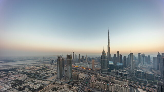 Aerial view of tallest towers in Dubai Downtown skyline and highway day to night timelapse.