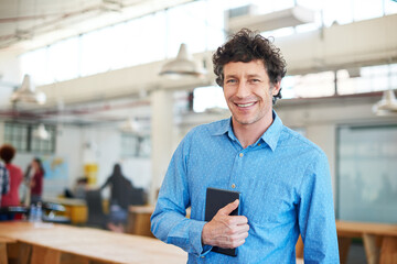 Modern business. Cropped shot of a handsome businessman working in the office with his colleagues...