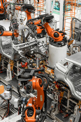 Vertical photo of automobile production line. Modern car assembly plant. Auto industry. Interior of a high-tech factory, modern production