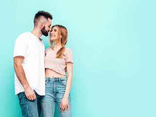 Sexy smiling beautiful woman and her handsome boyfriend. Happy cheerful family having tender moments near blue wall in studio.Pure cheerful models hugging.Embracing each other. Cheerful and happy