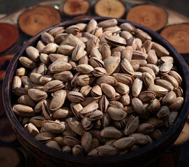 Pistachios with and without shell in wooden bowl 