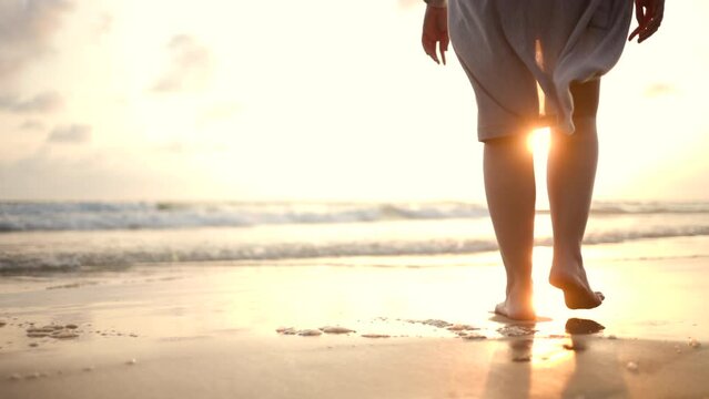 Young woman walk into the sea with sunset moment. Happy female relaxing on vacation time holiday weekend after hard work all day. Travel and resting on the beach concept.