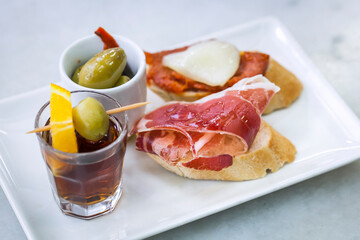Baked bread topped with bacon and served with a cocktail