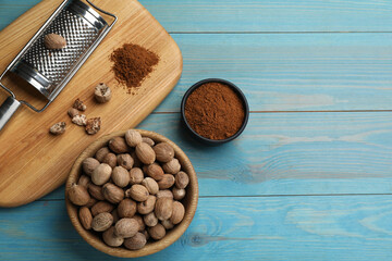 Flat lay composition with nutmeg powder and seeds on light blue wooden table, space for text