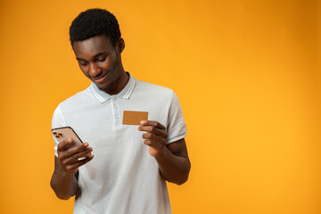Black man using credit card and smartphone for online shopping