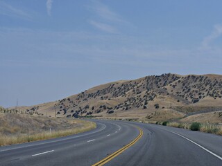 View along Highway 46 with sparse trees on the hillsides, California