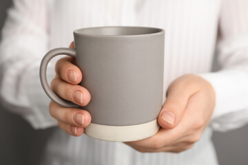 Woman holding mug of hot drink, closeup. Coffee Break