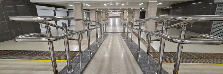 Handicapped ramp with metal railings in underpass background