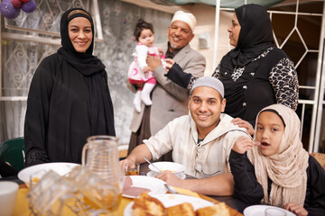 The end of the fast. Shot of a muslim family eating together. - obrazy, fototapety, plakaty