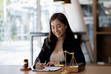 Woman sitting in the office, she's a good woman lawyer, she's a lawyer serving clients to fight cases, she's advising and fighting cases. that has been fully acknowledged. Lawyer concept and justice.
