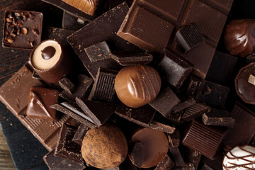 Chocolate candies and chocolate pieces pile for background