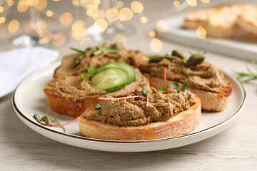 Slices of bread with delicious pate on white wooden table, closeup
