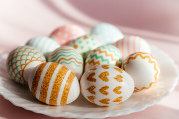 Easter eggs in pastel colors with a pattern lie on a white plate