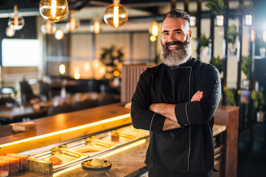 Portrait of cheerful sushi chef at sushi restaurant.
