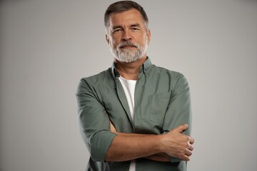 Portrait of smiling mature man standing on white background