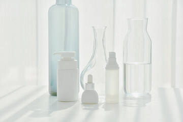 Cosmetic bottle containers and crystal clear glassware, Minimal skincare concept with light and shadow reflection effect, Purity cosmeceutical beauty care.